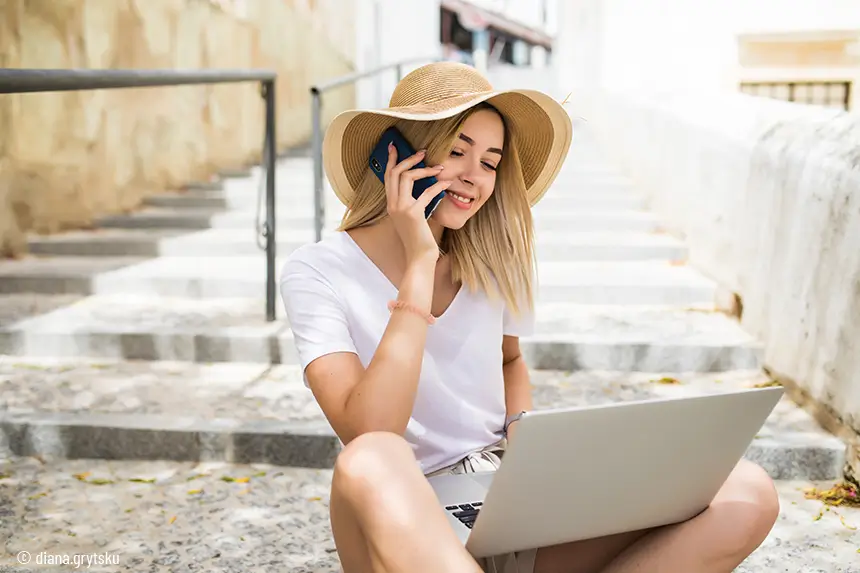 Jovem ao telemóvel com portátil